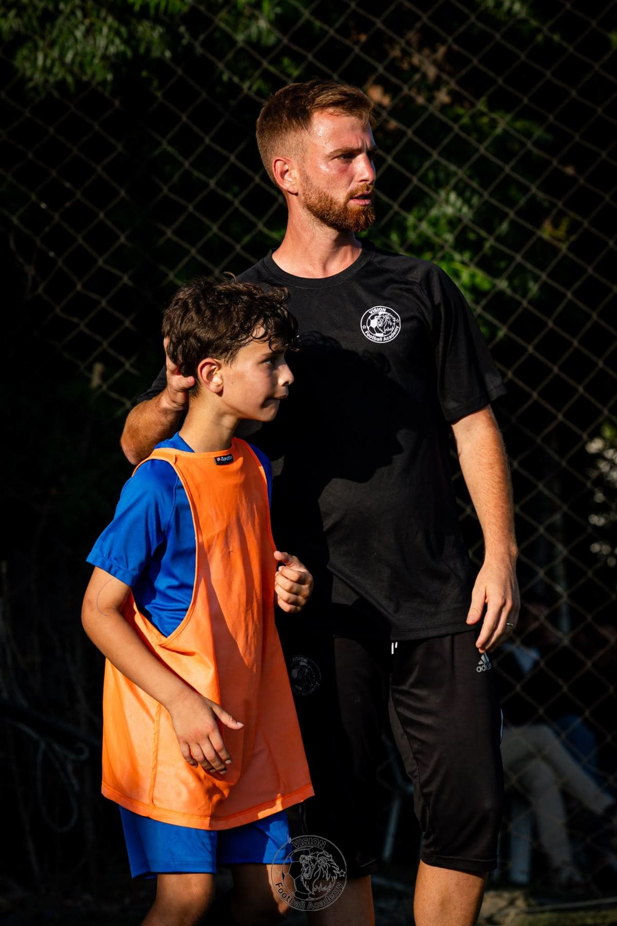 מאמן האקדמיה עם שחקן צעיר במהלך אימון
